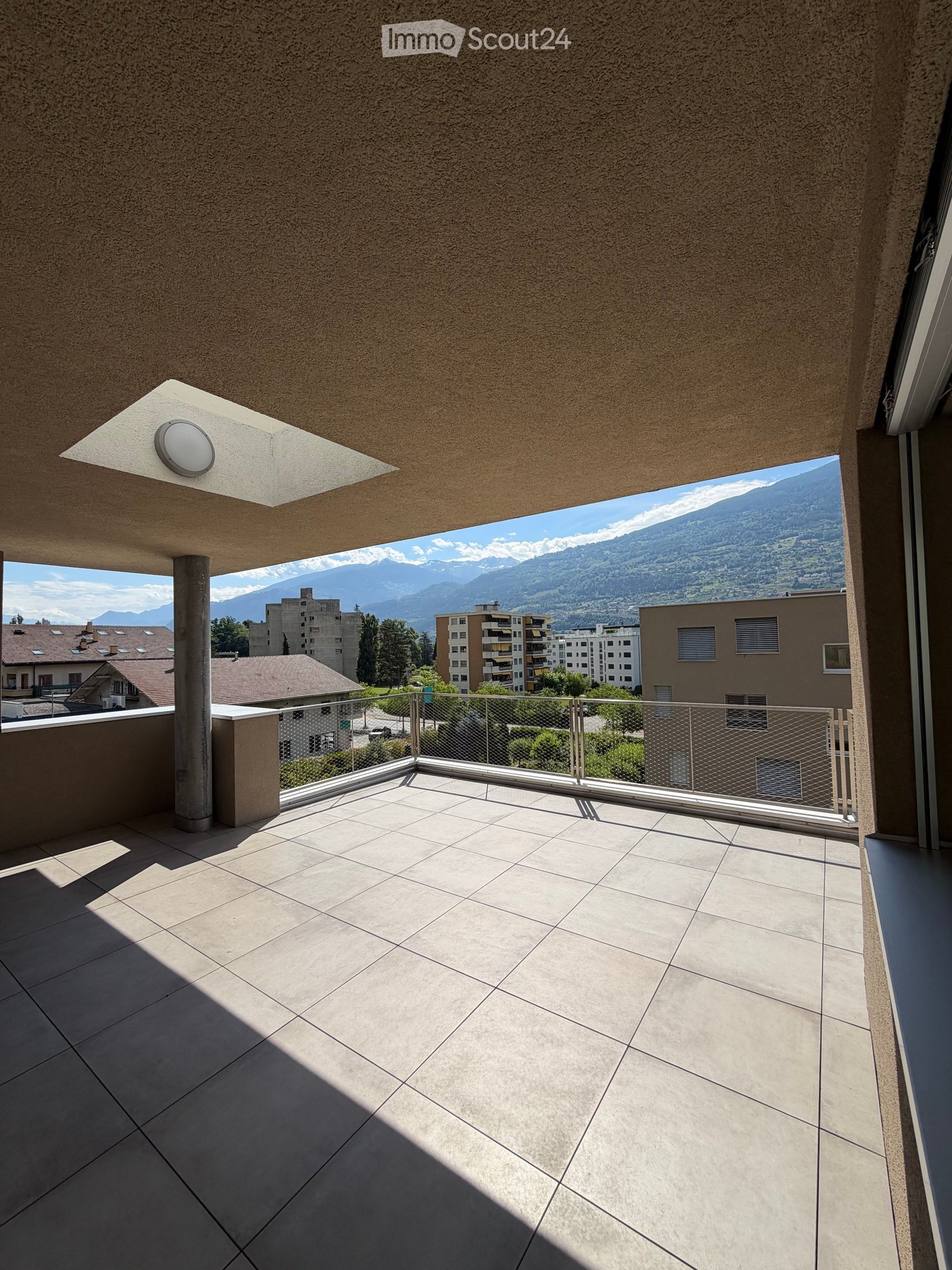 Balcony with tiled floor, metal railing, and scenic mountain view.