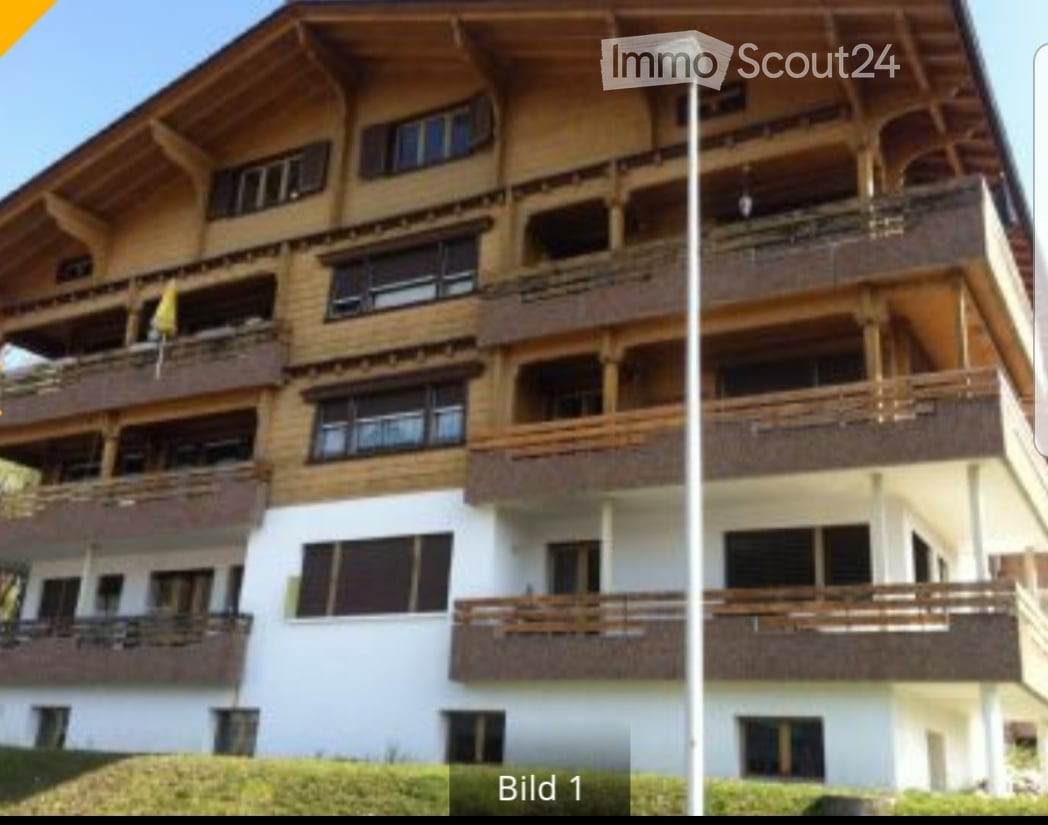 3 story building, wooden exterior, balconies, windows with shutters
