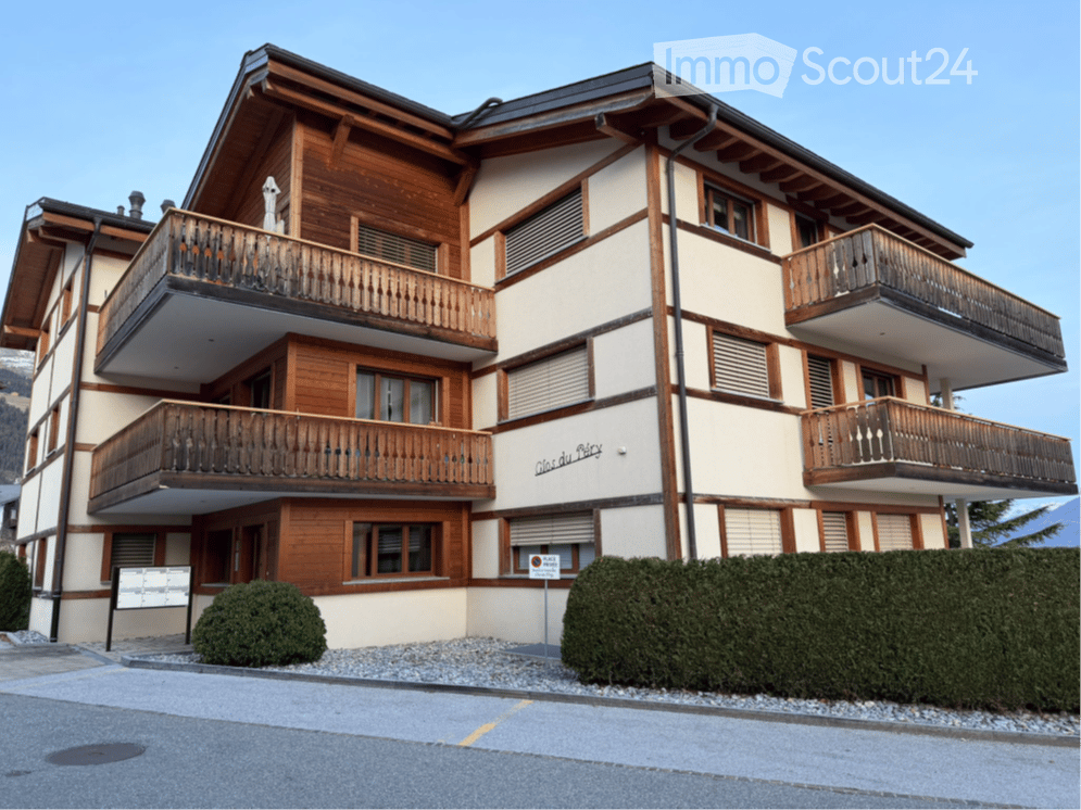Multi-story wooden building with balconies, large windows, and a sign reading "Clos du Péry".