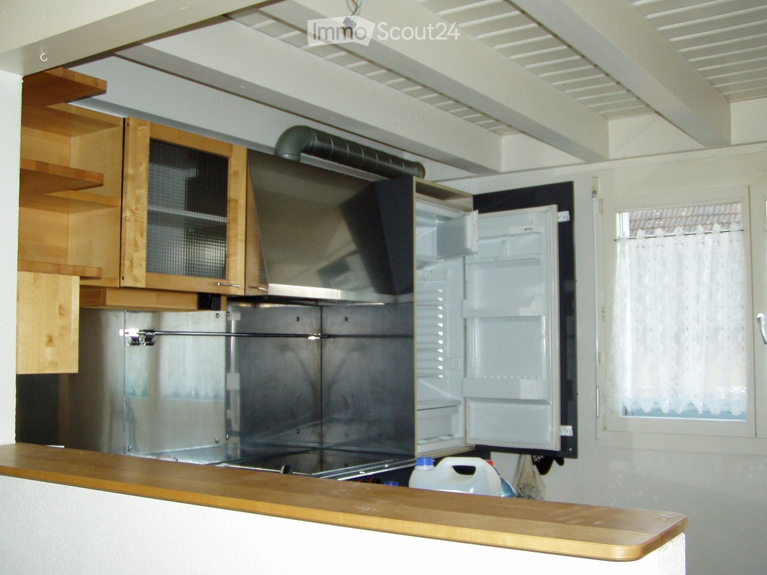 Modern kitchen with wooden cabinets, stainless steel appliances, and a wooden countertop.