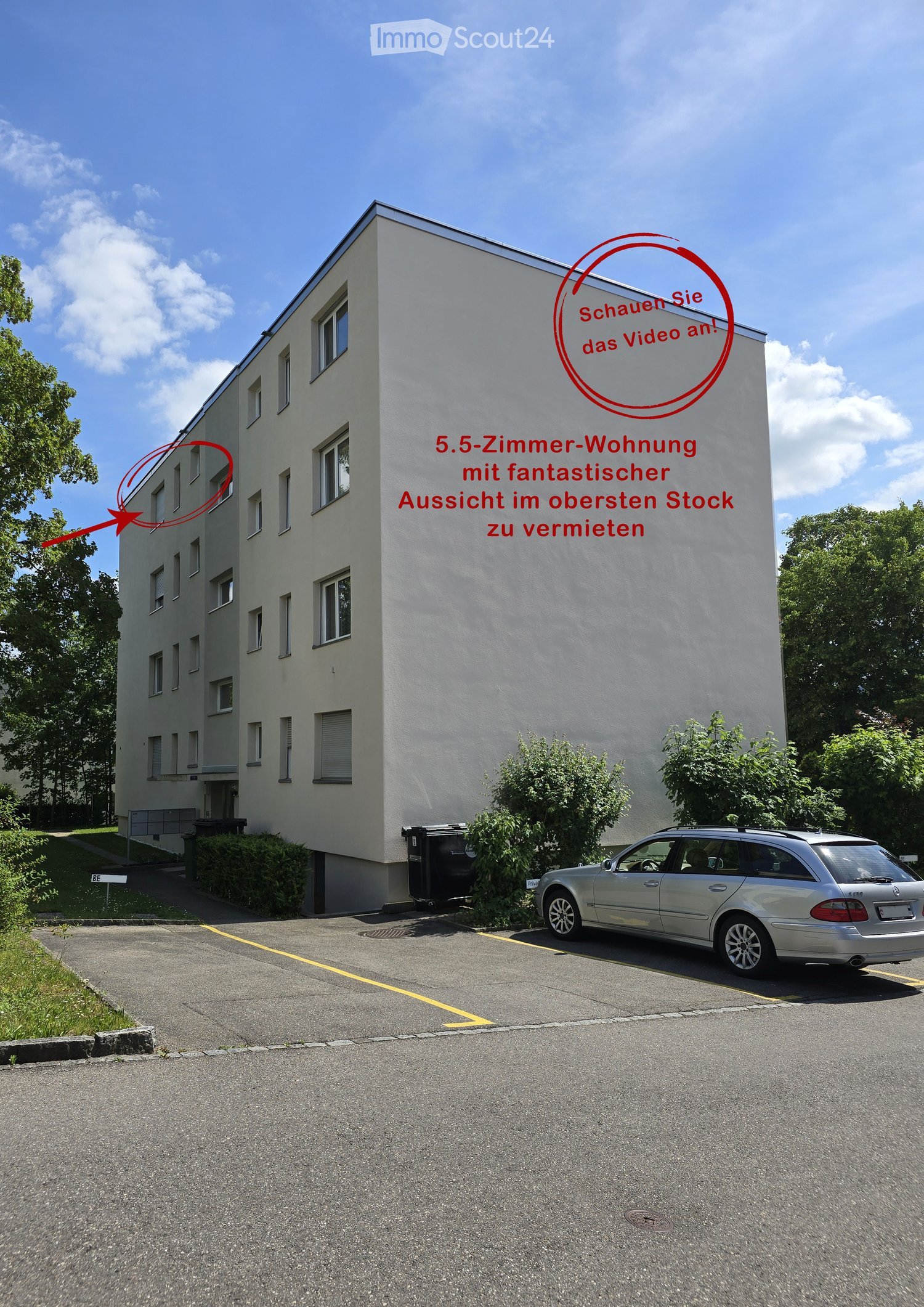 Multi-story building with multiple windows, a parked car in the foreground, and greenery around.