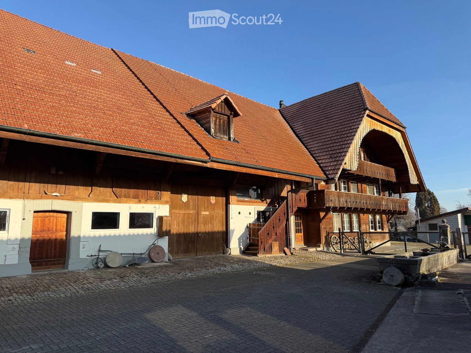 The exterior of a house made of red tiles, wooden beams, wooden doors, glass windows, and stairs.