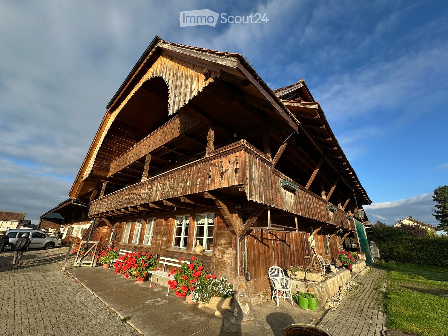 old wooden house, wooden balcony, red flowers, large windows, wooden fence