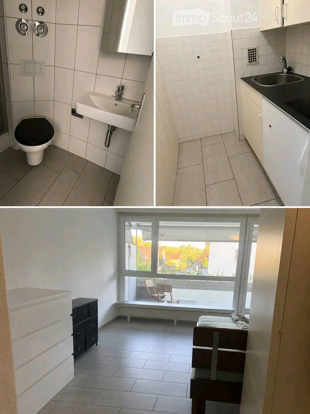 The image shows a modern, well-lit apartment with a bathroom, kitchen, and living area. The bathroom features a toilet, sink, and mirror. The kitchen has white cabinets, a sink, and a stove. The living area includes a bed, a chair, a small table, and a dr
