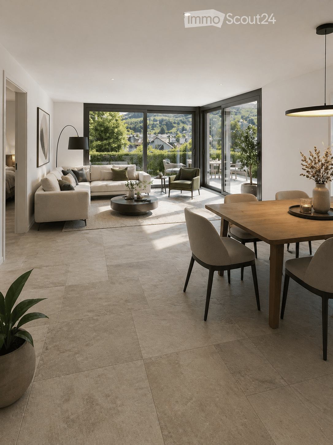 Modern living and dining area with large windows offering a scenic view, featuring a white sofa, coffee table, dining table with chairs, and decorative plants.