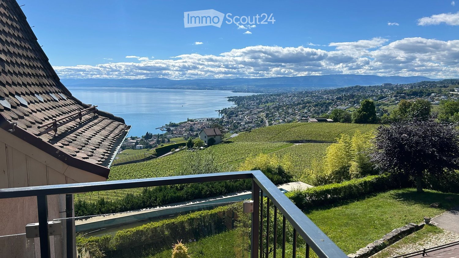 Balcony / Terrace. Balcony overlooking a scenic view of a lake, vineyards, and distant town with mountains in the background.