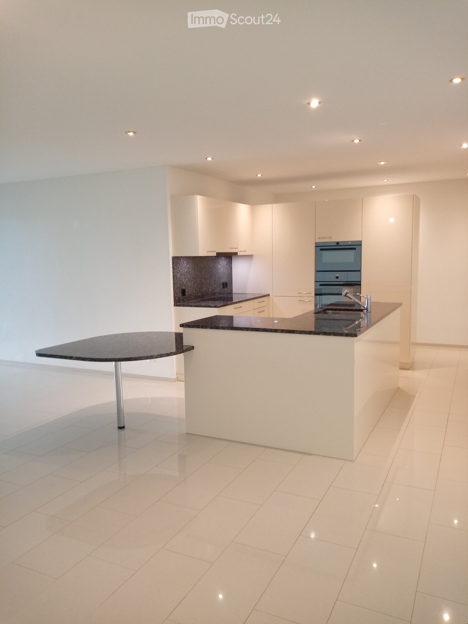 modern kitchen with white cabinets, black granite countertops, island with sink and faucet, built-in oven, dishwasher