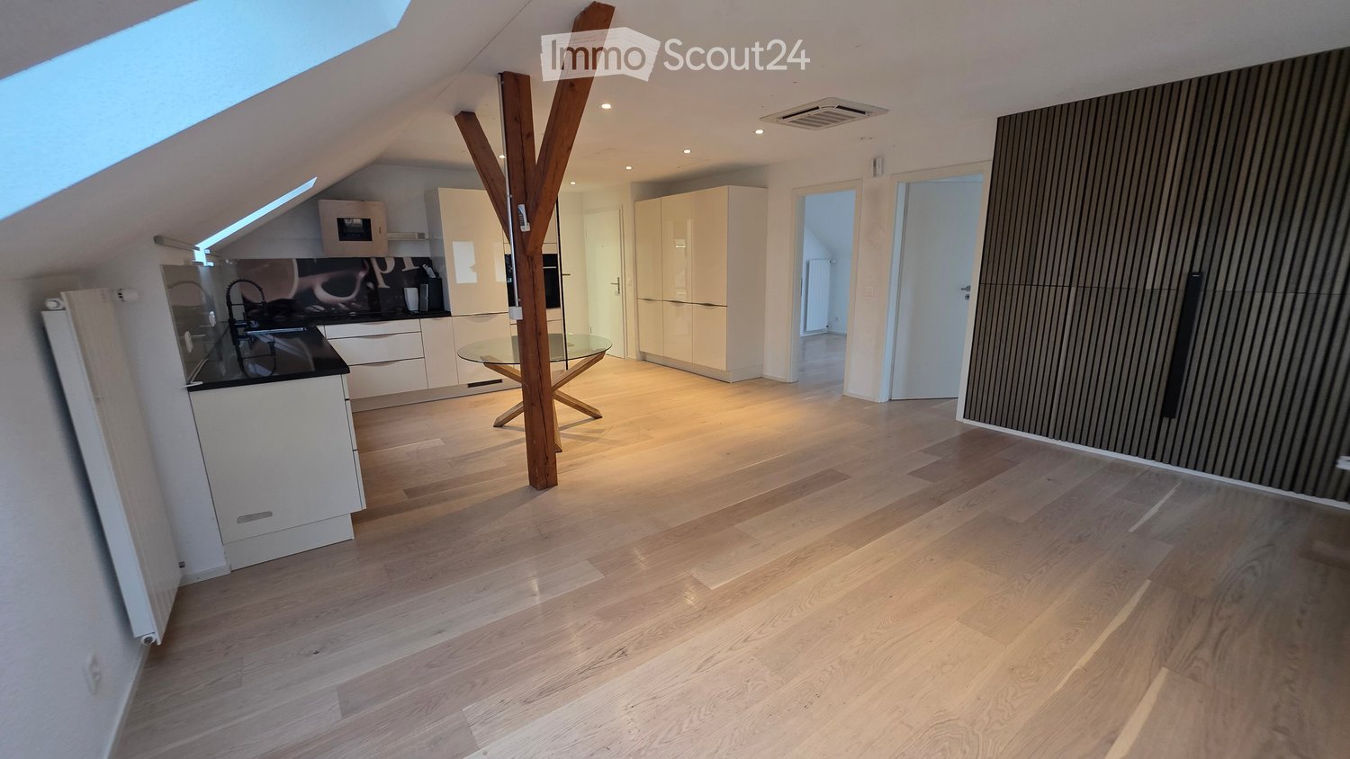 modern kitchen with wooden floor, white cabinets, glass table, wooden pillar, ceiling lights