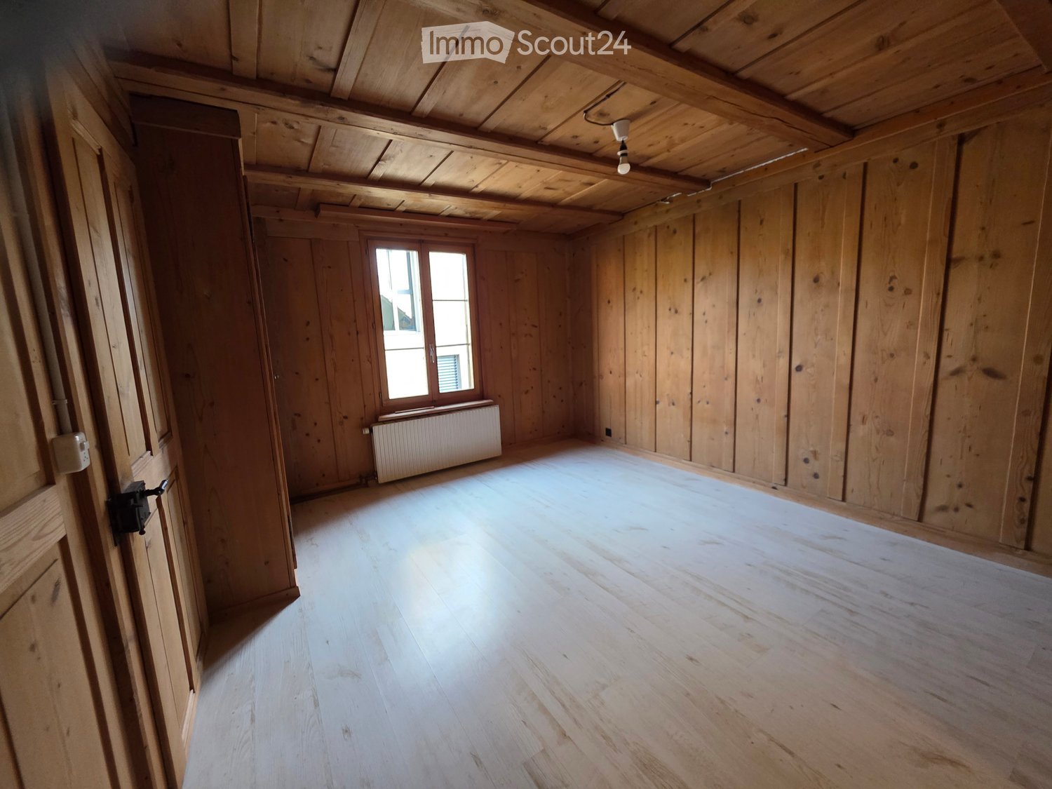 empty room, wooden walls, wooden floor, radiator, window, bright