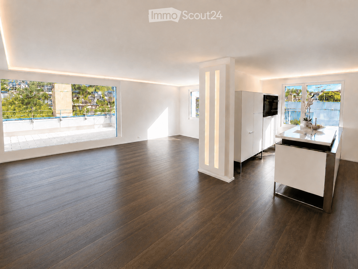 Modern kitchen with dark hardwood flooring, white cabinetry, and a central island with a sink and faucet. Large windows offer a view of a balcony area.