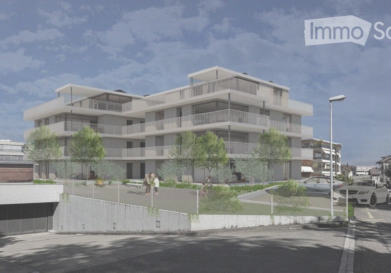 Modern multi-story residential building with balconies, surrounded by trees and a paved area with parked cars.