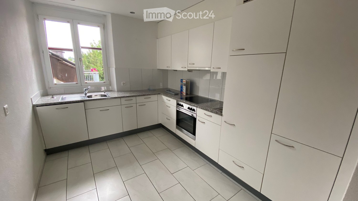 modern kitchen with white cabinets, granite countertops, stainless steel appliances, and a window with a view
