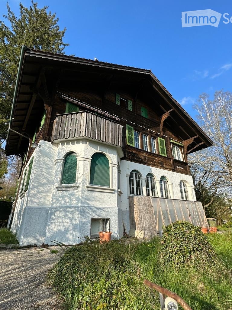 2 story house, wooden exterior, white walls, green shutters, balcony, large windows, driveway