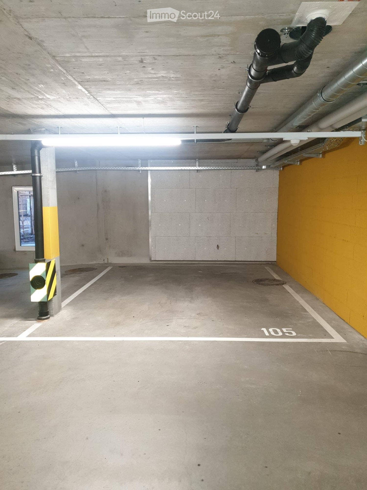 {"type": "Garage", "objects": [], "description": "Underground parking space with concrete floors and walls, marked parking spot number 105, fluorescent lighting, and ventilation ducts.", "localized_descriptions": {"EN": "Underground parking space with con