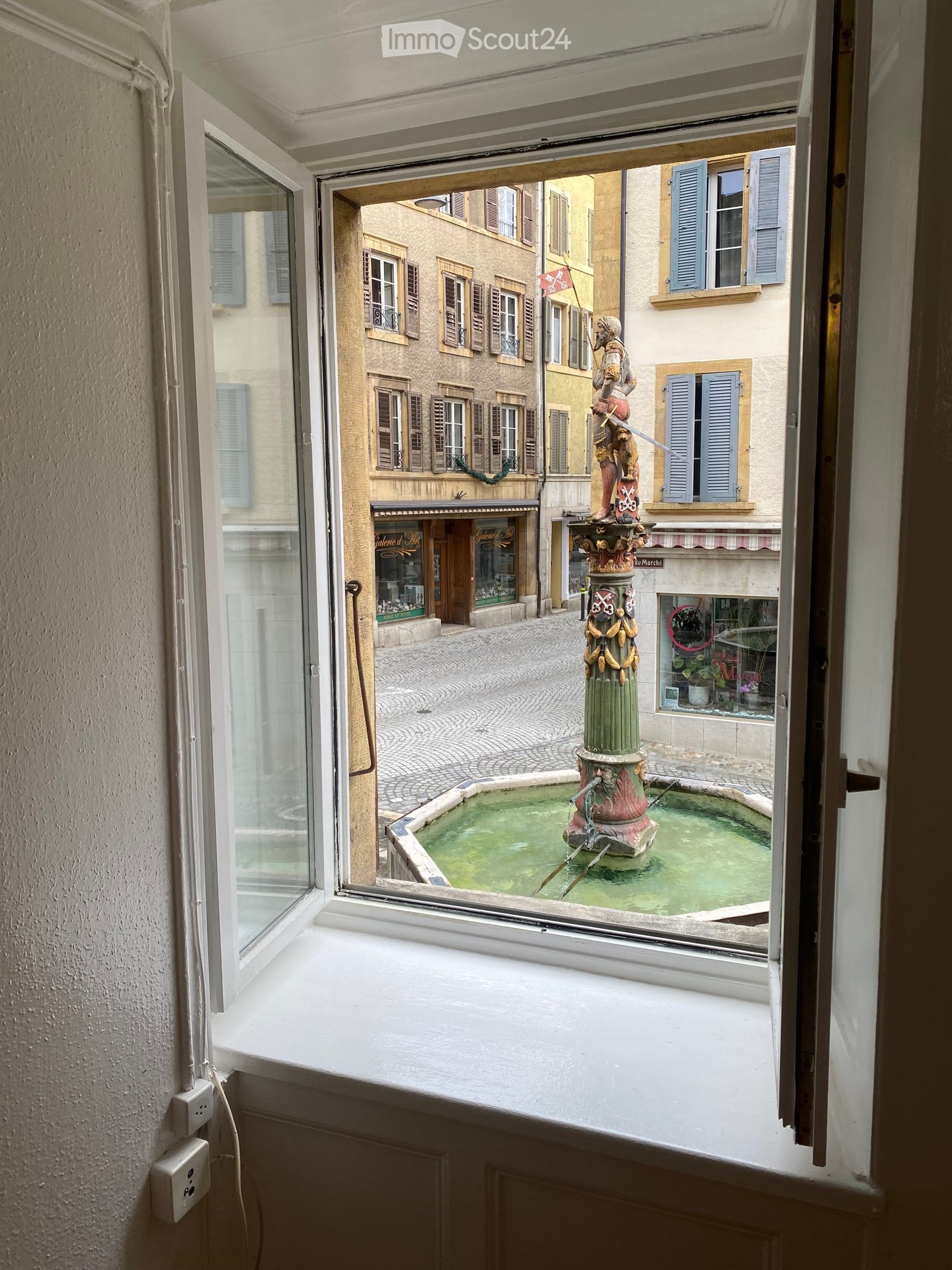 View from window showing a fountain in a street outside