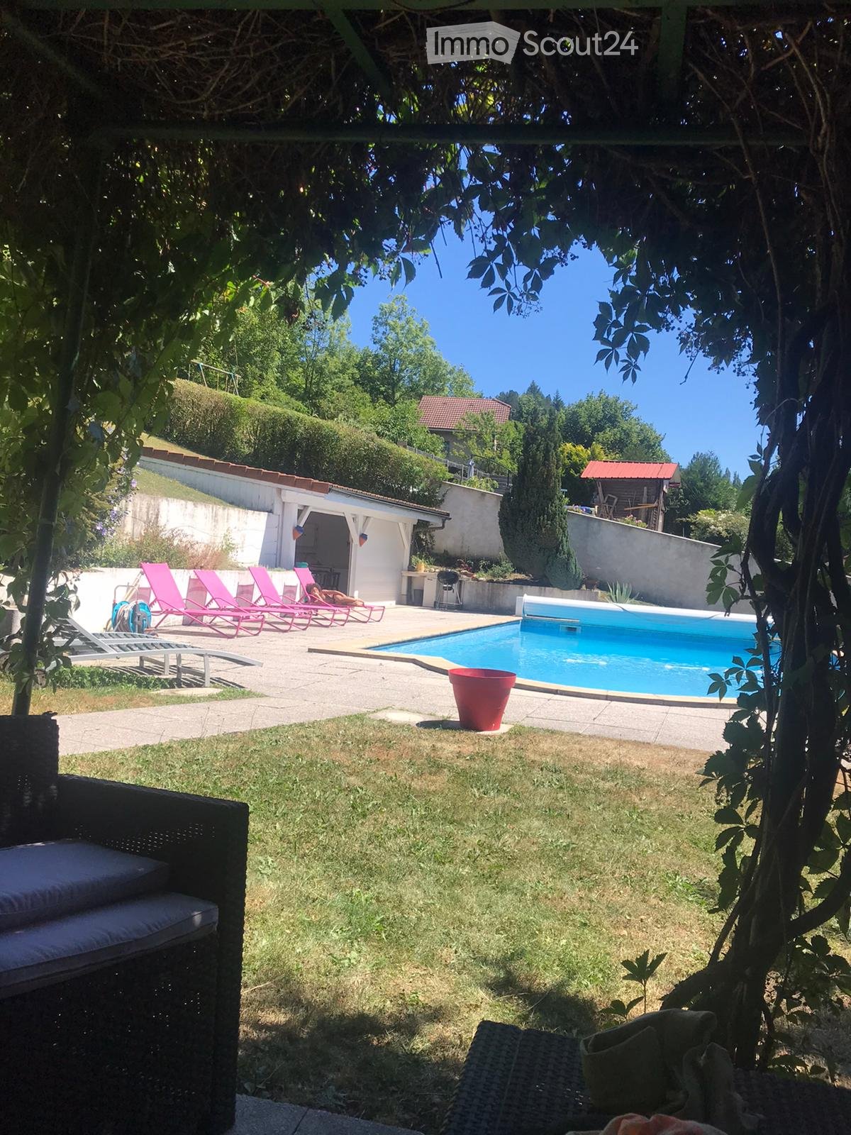 Garden with a swimming pool, lounge chairs, and a grassy area.