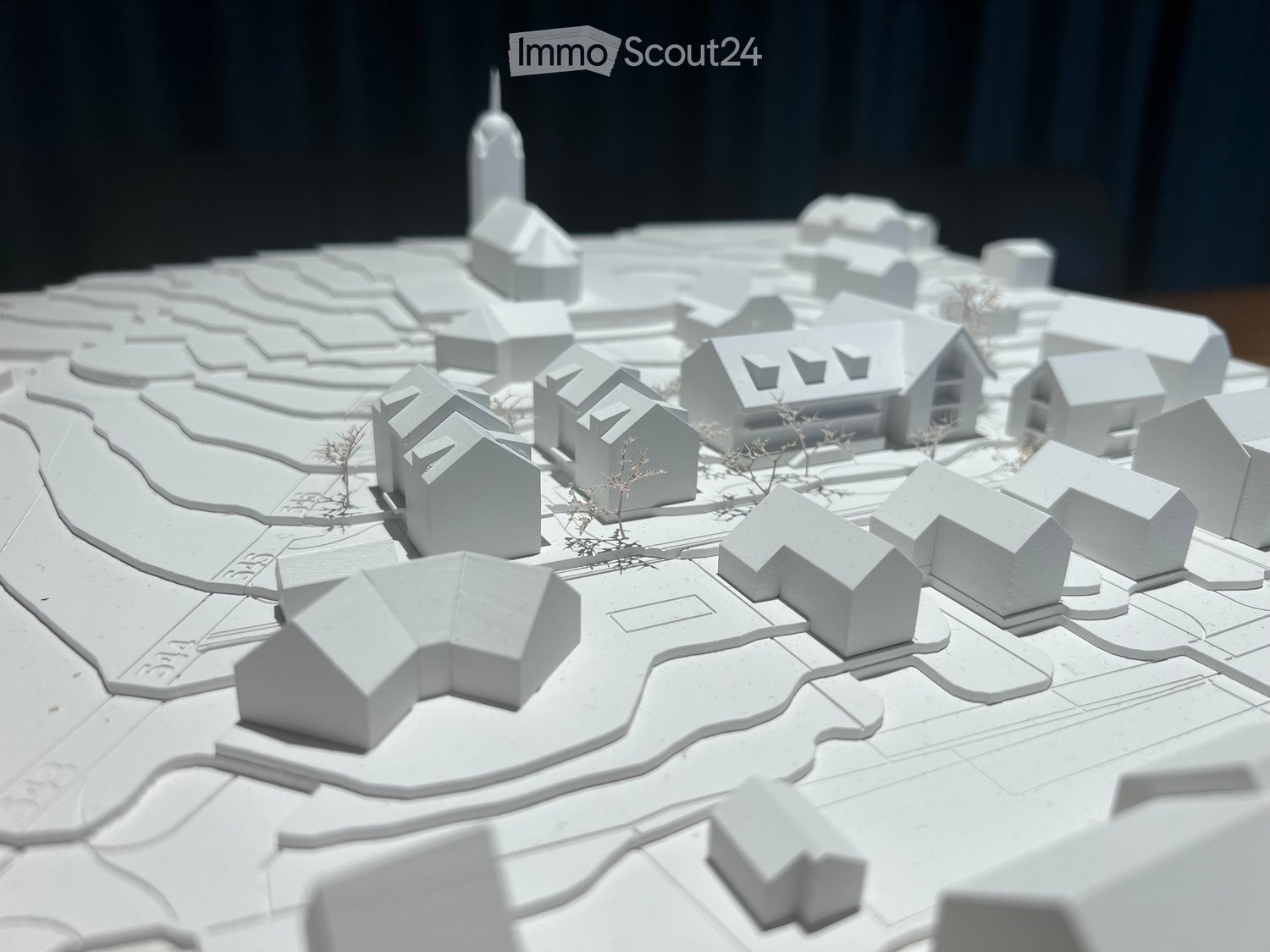 3D model of a small town with multiple houses, pathways, and a central tower-like structure.