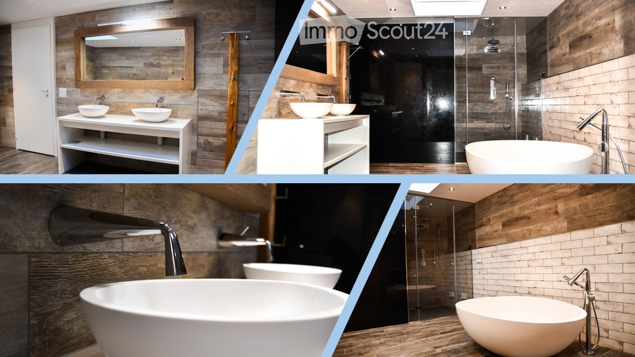 Modern bathroom with wooden accents, white sinks, a large bathtub, and a glass-enclosed shower area.