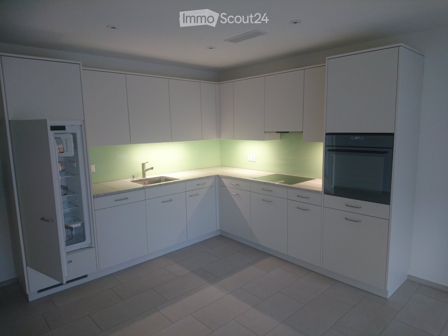 modern kitchen, white cabinets, green backsplash, stainless steel appliances, double oven, dishwasher, refrigerator, ceramic flooring