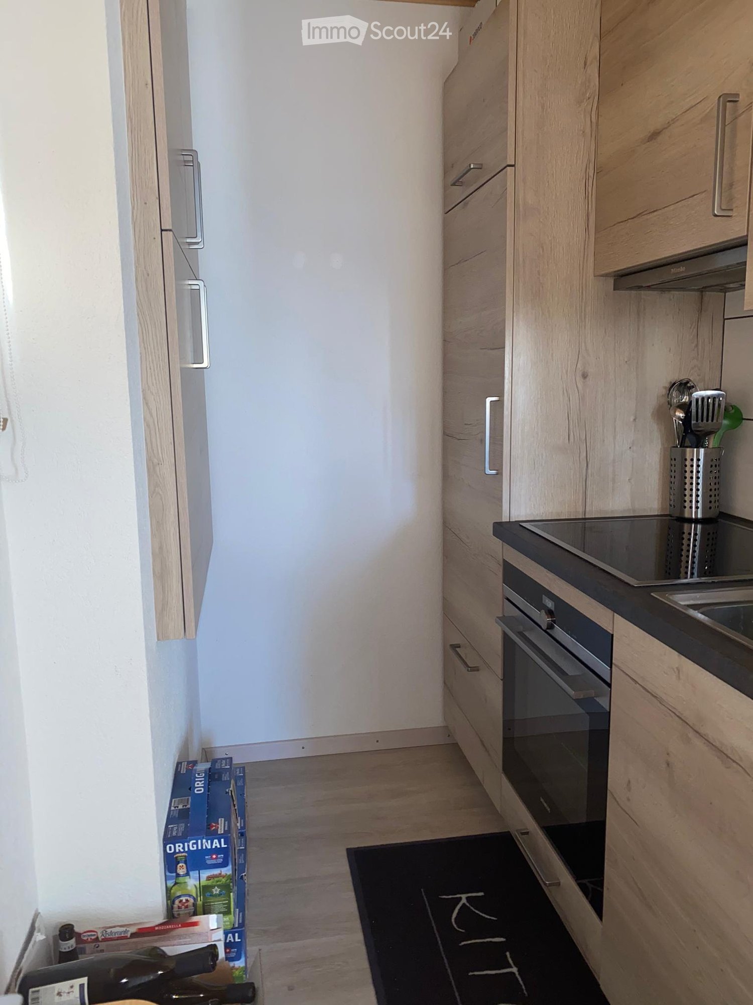 kitchen with wooden cabinets, black countertop, oven, sink, and a black mat