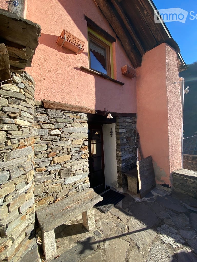 Stone wall, wooden door, window, lamp, bench, stone floor