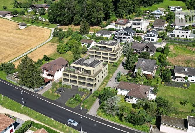 Aerial view of a residential area with multiple houses, garages, and parking spaces.