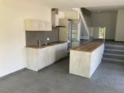 Modern kitchen with light-colored cabinets, a central island, and a sink area. The space is clean and well-lit, with a contemporary design.
