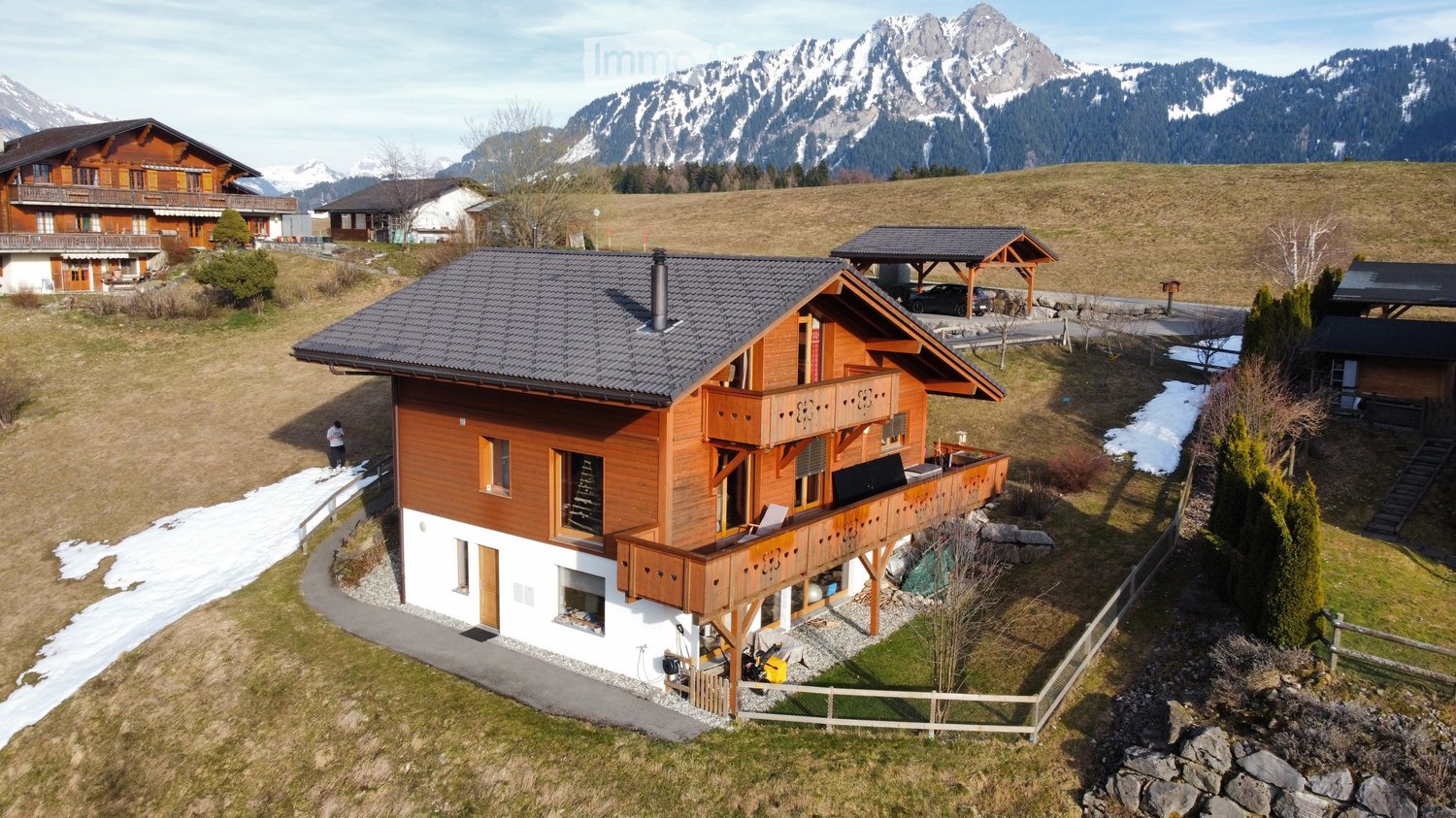 Detached house, wooden exterior, two-story, balcony, snowy mountain background