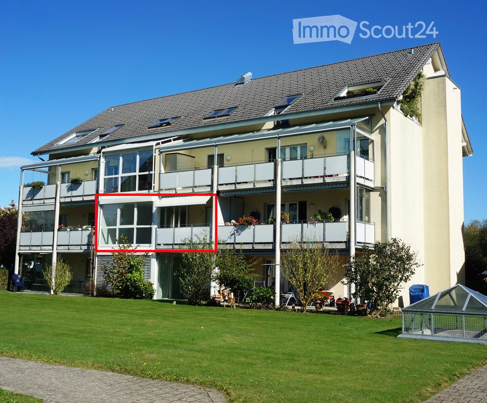 Modern two-story house with multiple balconies, large windows, and a well-maintained lawn.