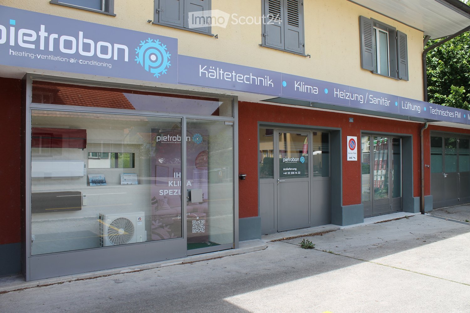 Building exterior with signage for "Pietrobon" and "Kältetechnik," featuring glass storefronts, air conditioning units, and multiple doors.