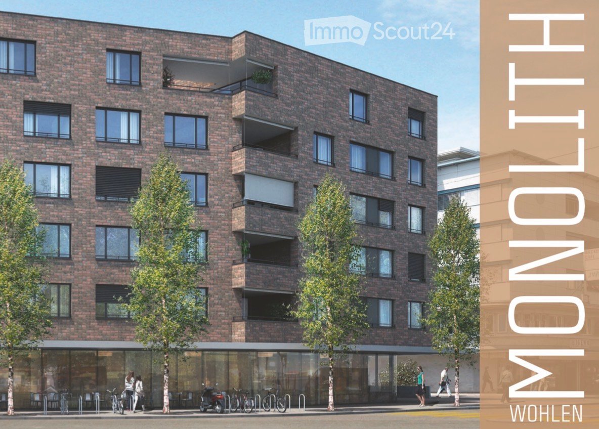 Modern multi-story brick building with large windows, balconies, and greenery around the base.