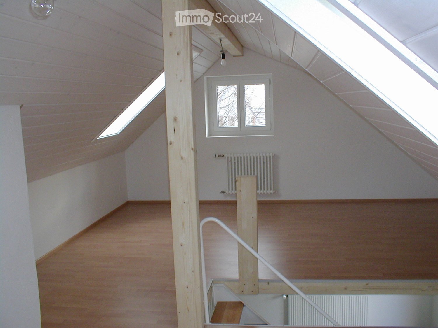 attic room, hardwood floors, white walls, radiator, wooden beams, staircase, skylights