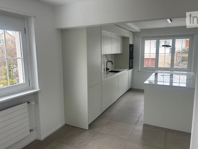 modern kitchen with white cabinets, tiled floor, under-mount sink, pendant light, microwave, refrigerator, windows