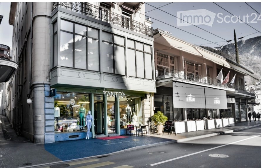 A multi-story building with large windows and balconies, featuring a storefront with mannequins and signage for "Yantra" and "Le Bistrot".