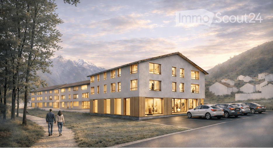 Modern multi-story building with large windows and wooden accents, situated in a scenic mountainous area with a parking lot and a view of the surrounding landscape.