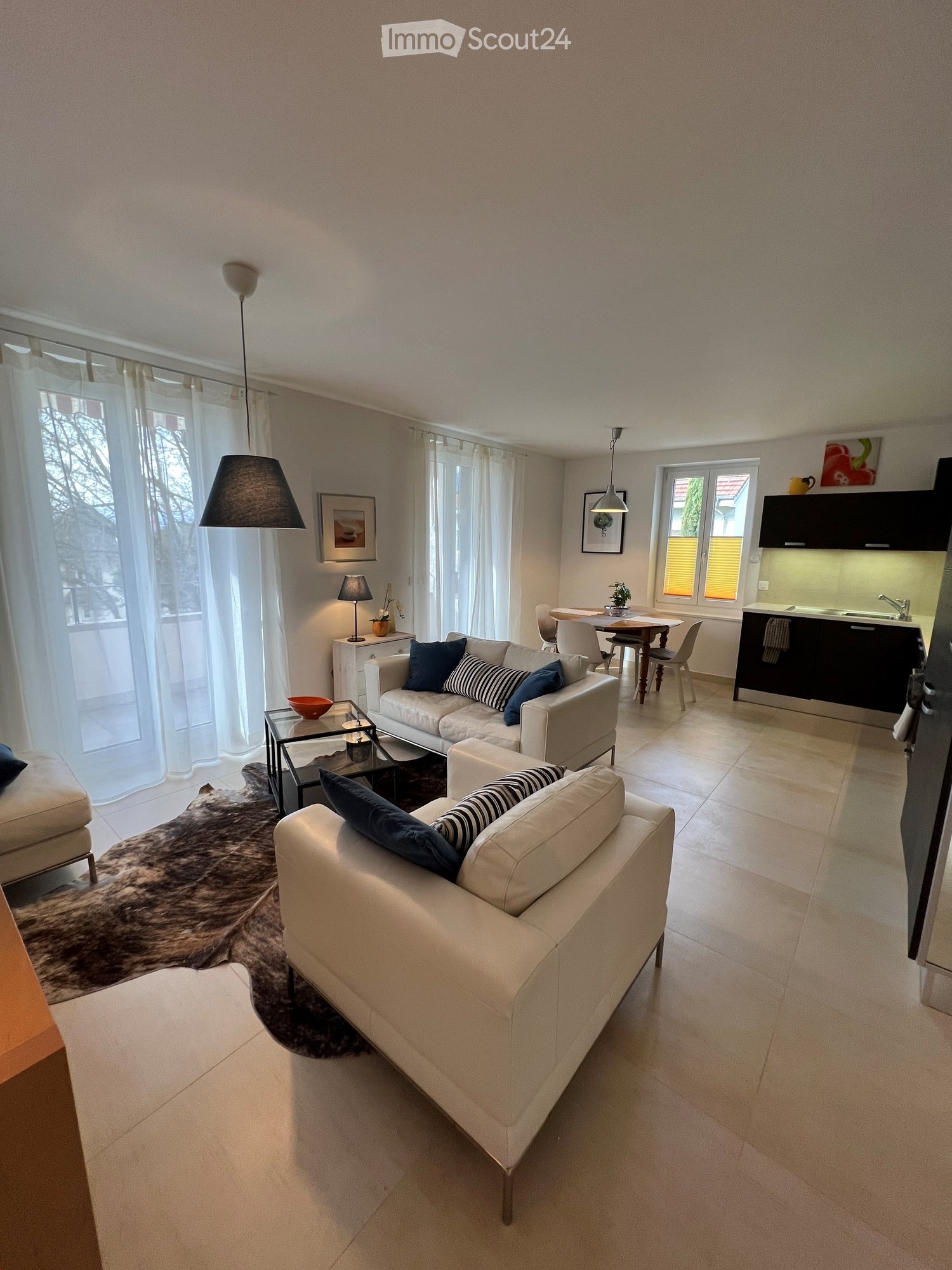 White leather sofas, beige carpet, modern glass coffee table, decorative items, table and chairs, modern kitchen set