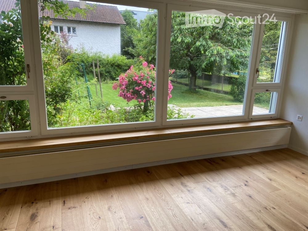 large windows, wooden floor, bench, radiator, garden view