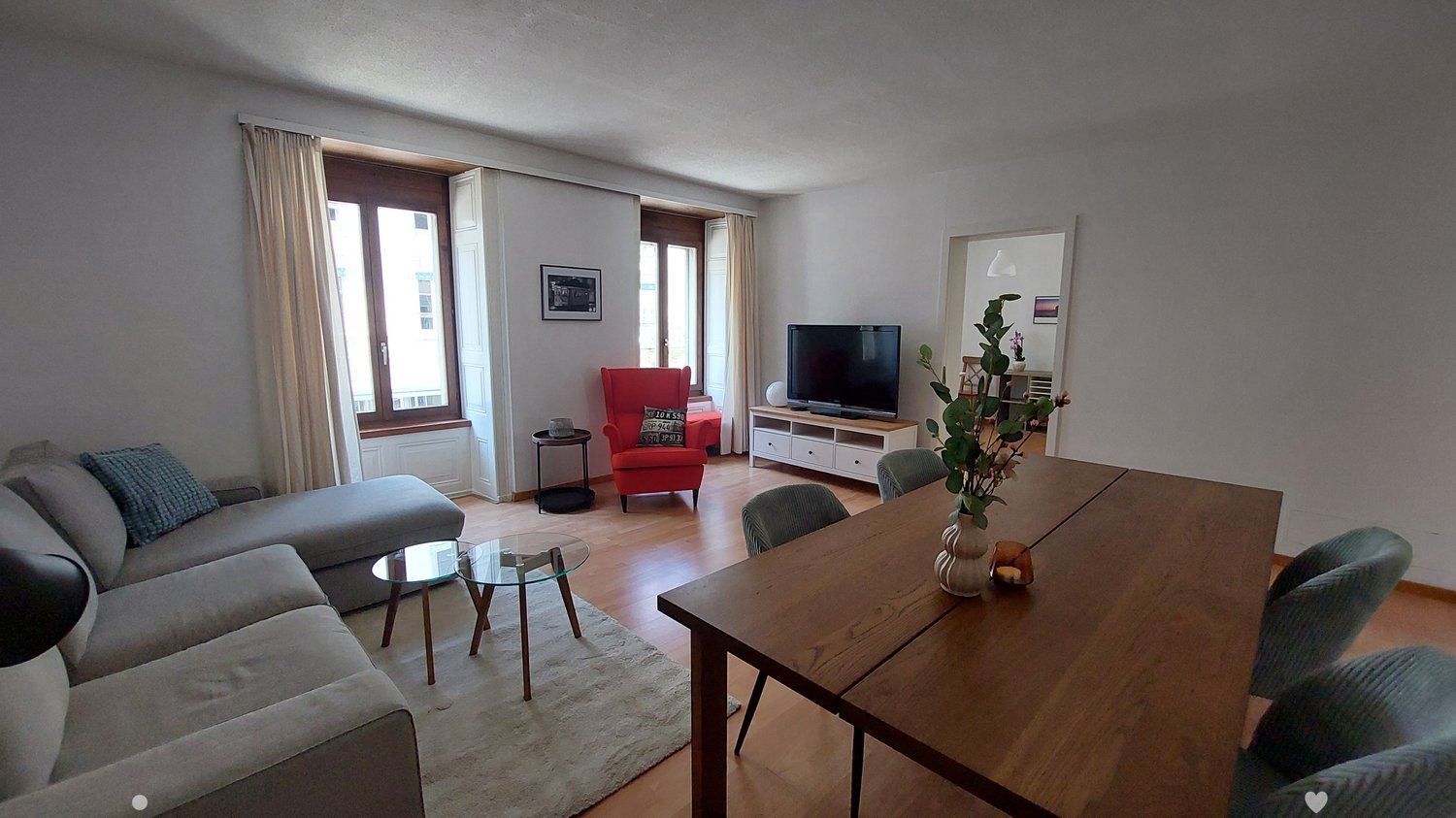 Dining room: table with chairs, living room visible in the background, TV, lamp