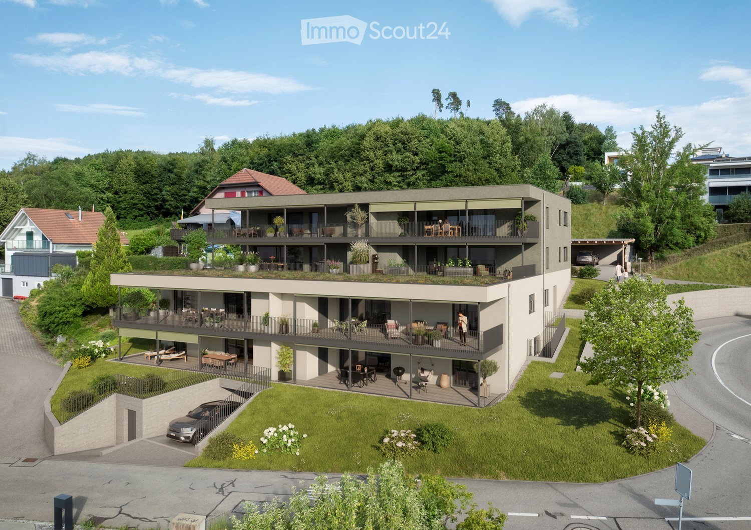 A modern, multi-story residential building with balconies, greenery, and a parking area. The structure features contemporary design with large windows and outdoor seating areas.