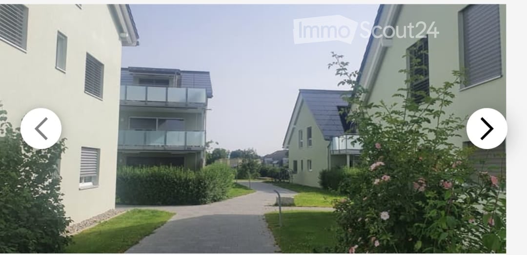 Residential complex with modern buildings, balconies, and landscaped gardens.