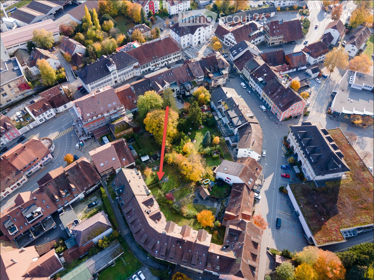 Aerial view of a residential neighborhood with multiple houses, streets, and parked cars.