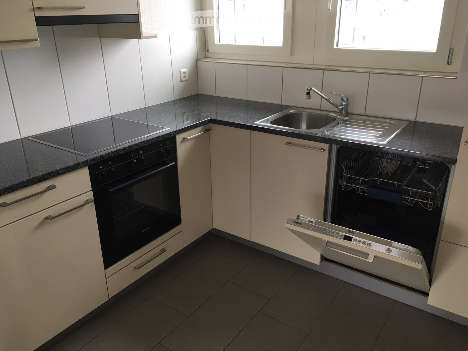 modern kitchen with black counter, electric stove, oven, dishwasher, and sink