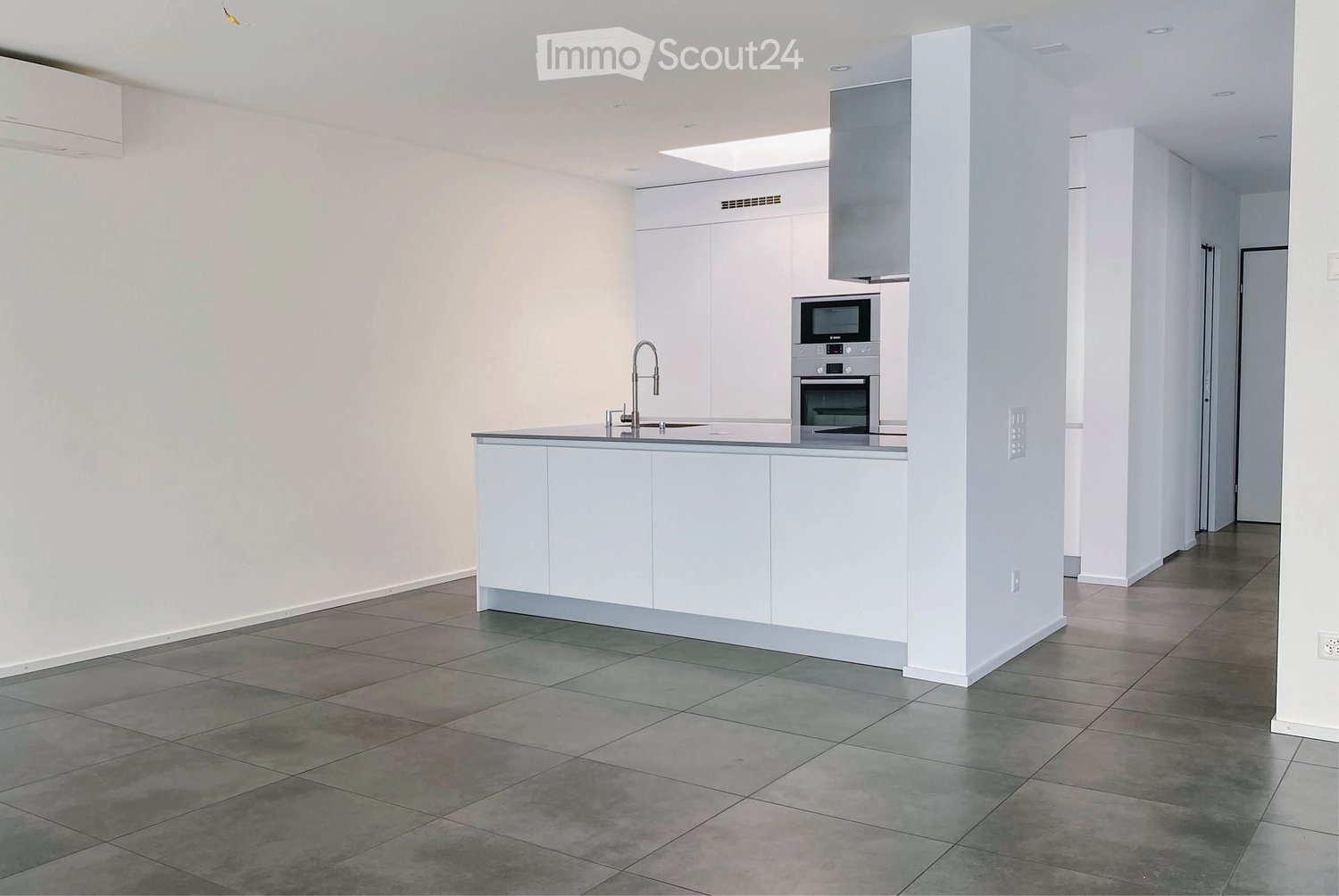 Modern kitchen with white cabinets, stainless steel appliances, and a central island with a sink and faucet.