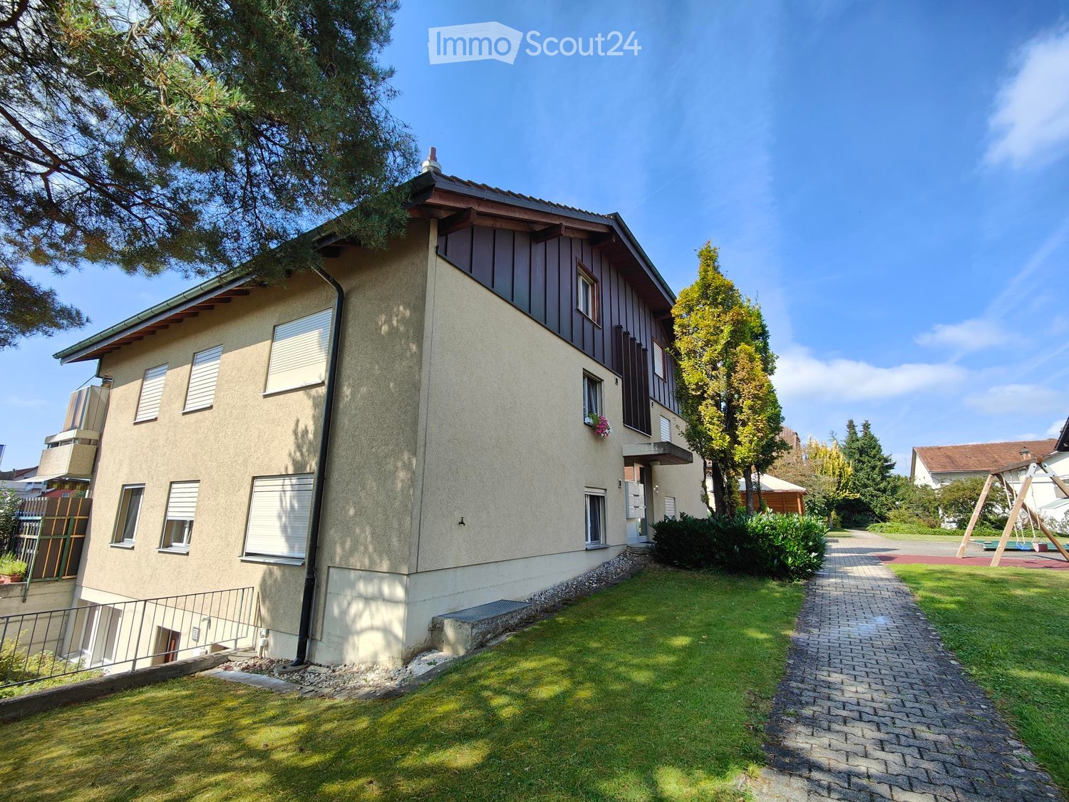 3 story house, beige exterior, brown roof, multiple windows, small garden, brick pathway