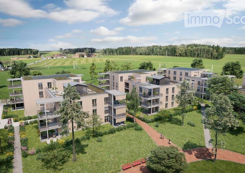 Building. Aerial view of a modern residential complex with multiple apartment buildings, green spaces, and pathways.