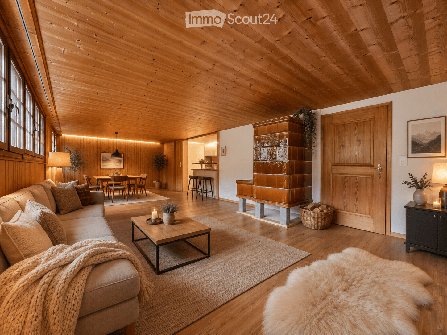 Cozy living room with wooden beams, a fireplace, a sofa, coffee table, side table, and a dining area visible in the background.