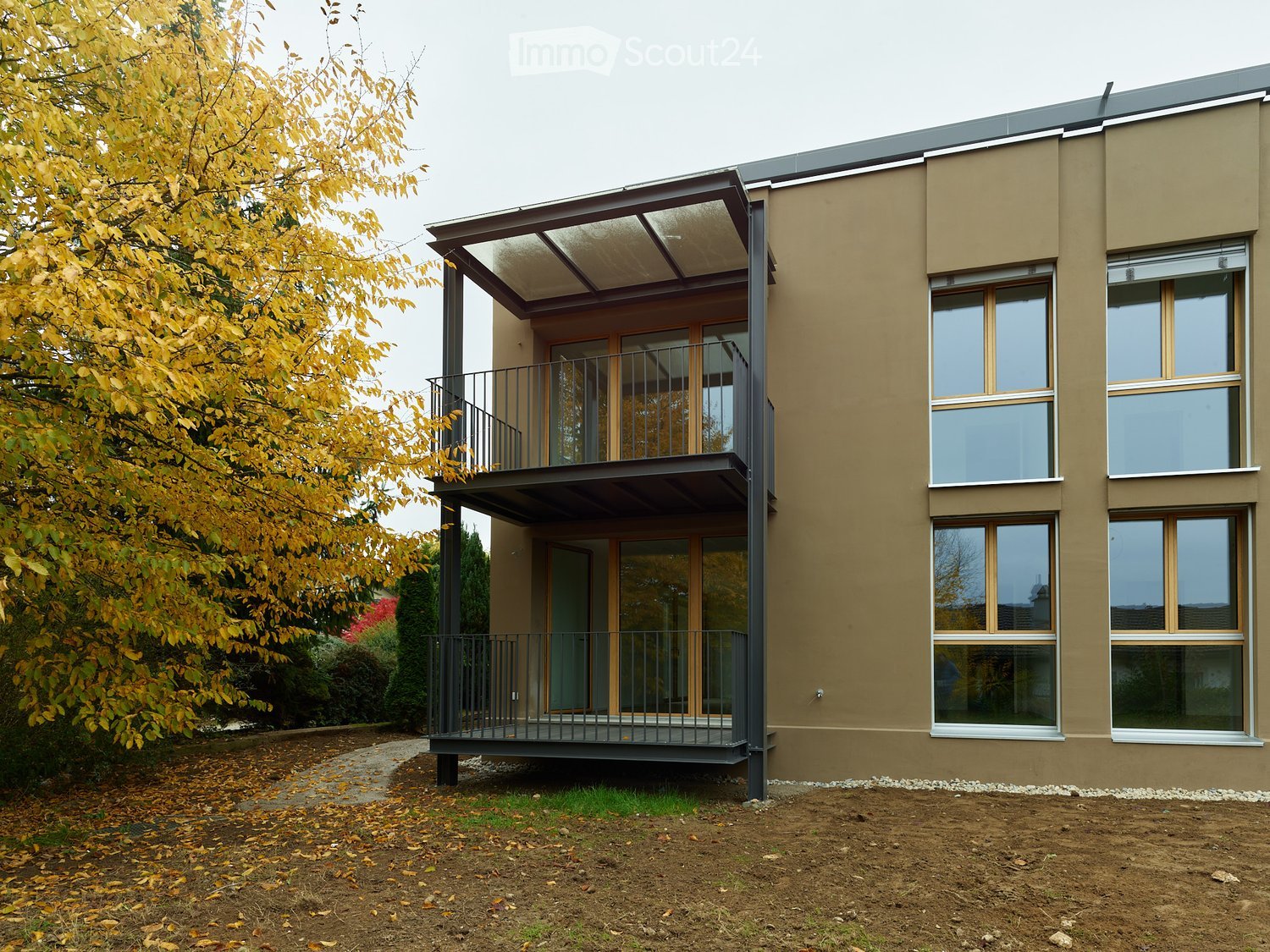 Modern design house with a balcony on the second floor and large glass windows