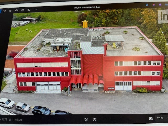 a red commercial building with white windows, garage, cars parked in front
