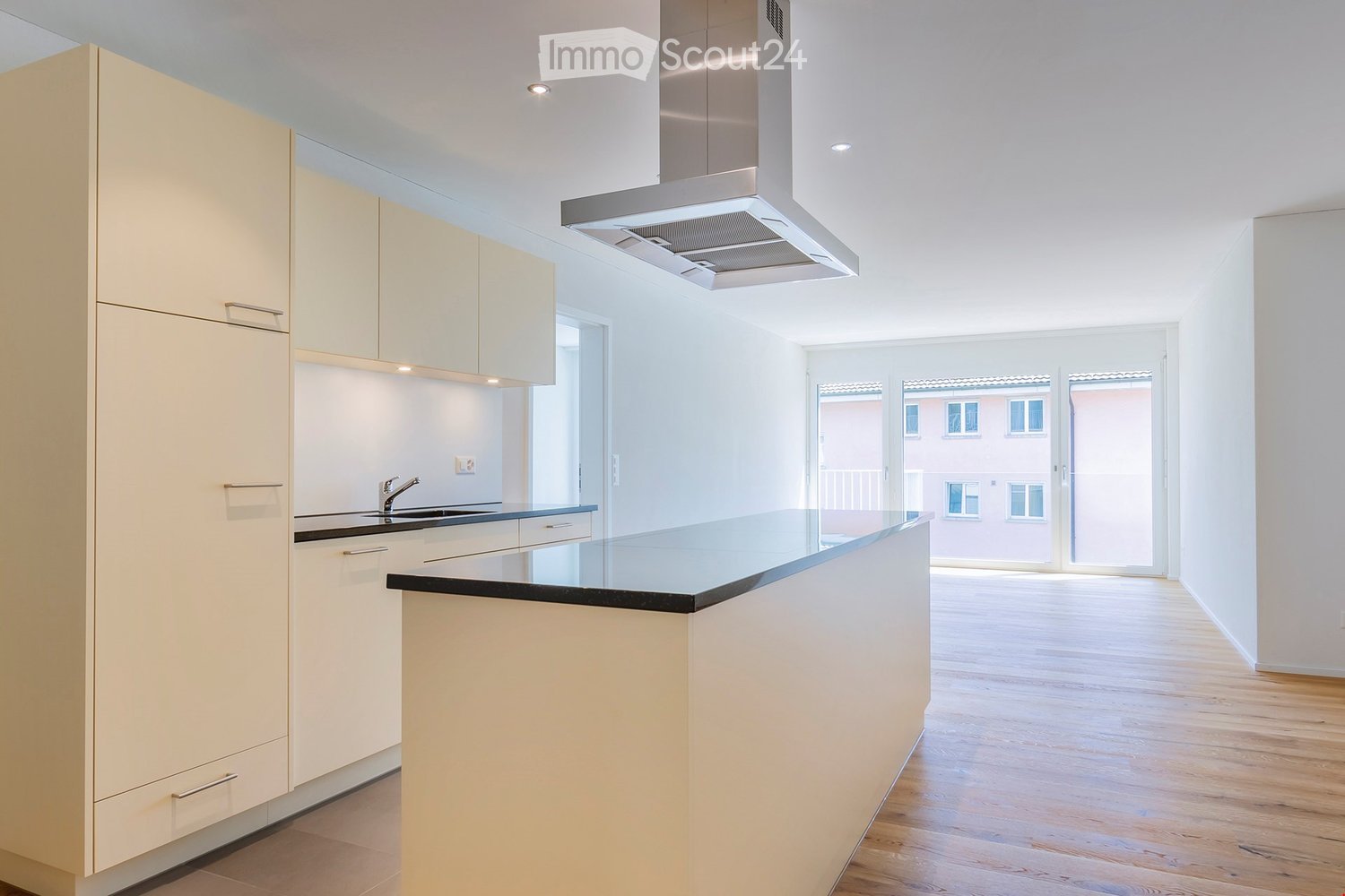 Modern kitchen, wooden floor, white cabinets, black countertop, stainless steel exhaust hood