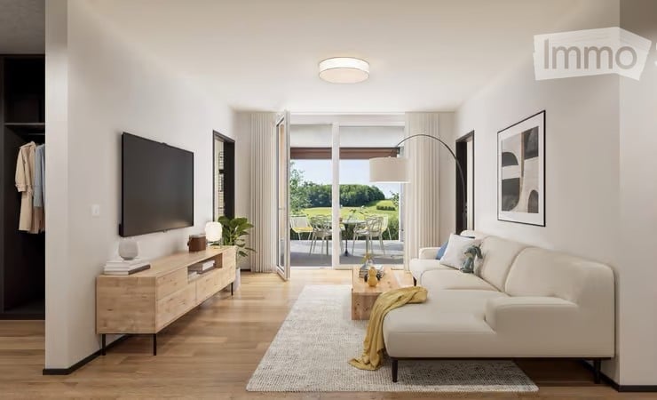 Modern living room with white walls, wooden flooring, large sliding glass doors leading to a balcony, a white sectional sofa, coffee table, TV stand, floor lamp, side table, and a small plant.